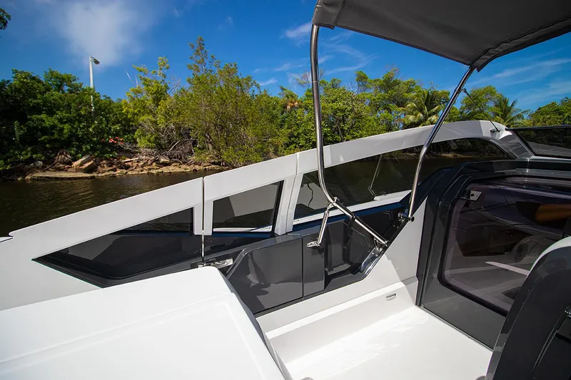 Slide: The Image of 2021 Fairline F Line 33 yacht cockpit with lush greenery in the background. - 27