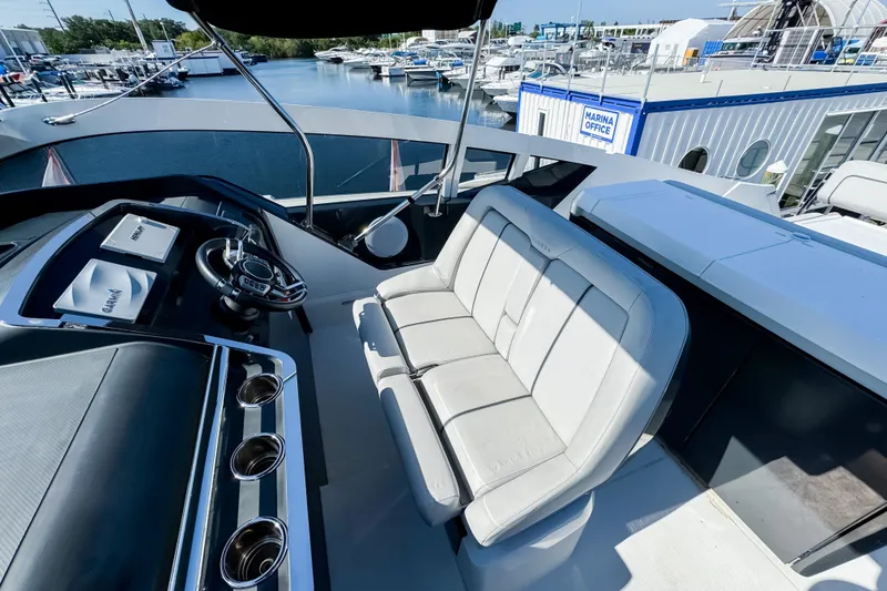 Slide: The Image of 2021 Fairline F Line 33 yacht cockpit with steering wheel and seating at marina. - 32