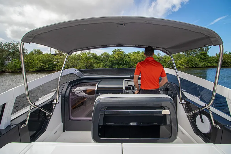 Slide: The Image of 2021 Fairline F Line 33 yacht cockpit with canopy and person at helm. - 37