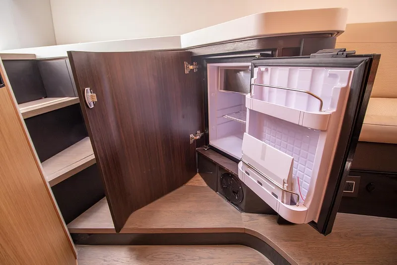 Slide: The Image of Fairline F Line 33 2021 yacht interior with open mini fridge and storage shelves. - 51
