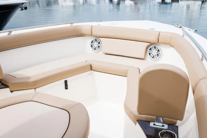 Slide: The Image of 2023 Scout 240 XSF boat interior with beige seating and speakers. - 29