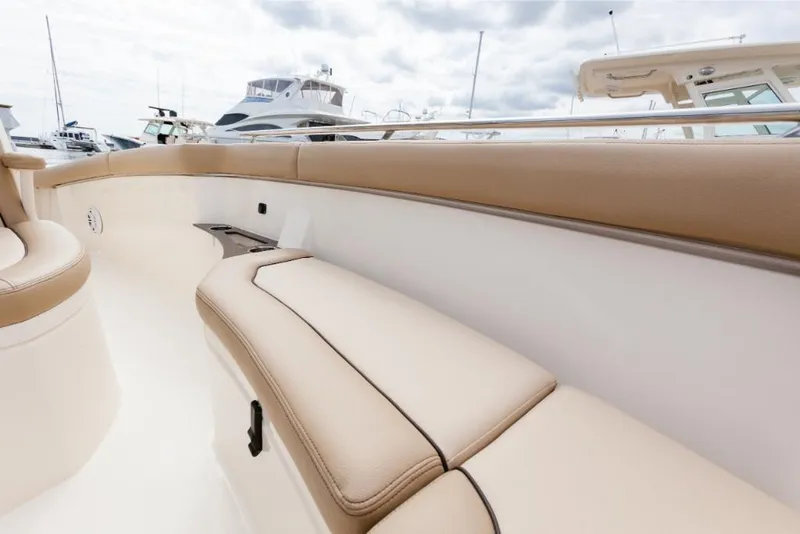 Slide: The Image of 2023 Scout 240 XSF boat interior with beige seating and white deck. - 33