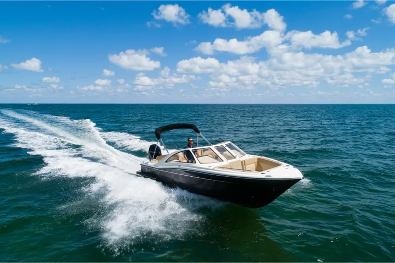 Slide: The Image of 2023 Scout 240 Dorado boat cruising on open water under a clear blue sky. - 0
