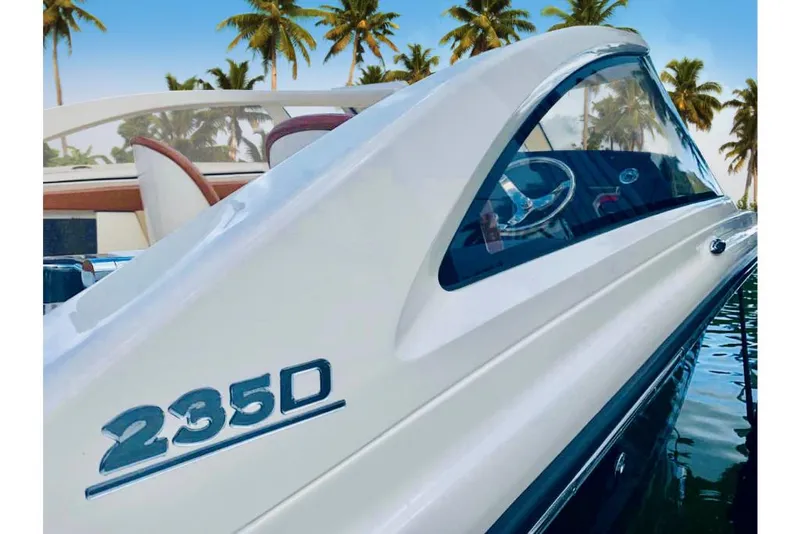 Slide: The Image of 2023 Scout 240 Dorado boat with 235D emblem, docked near palm trees. - 10