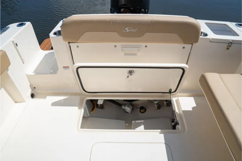 Slide: The Image of 2023 Scout 240 Dorado boat with open storage compartment and beige seating. - 16