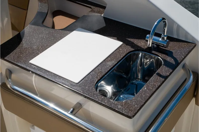 Slide: The Image of 2023 Scout 240 Dorado boat kitchen sink and cutting board. - 26