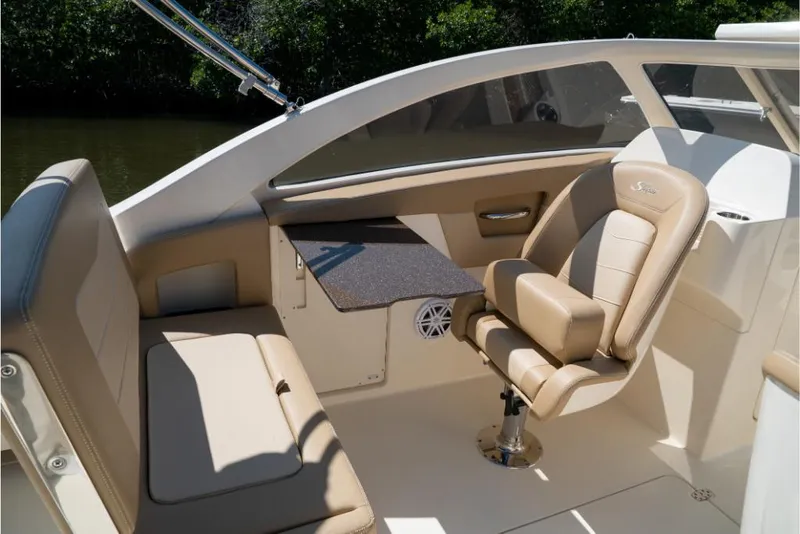 Slide: The Image of 2023 Scout 240 Dorado boat interior with beige seating and a small table. - 34