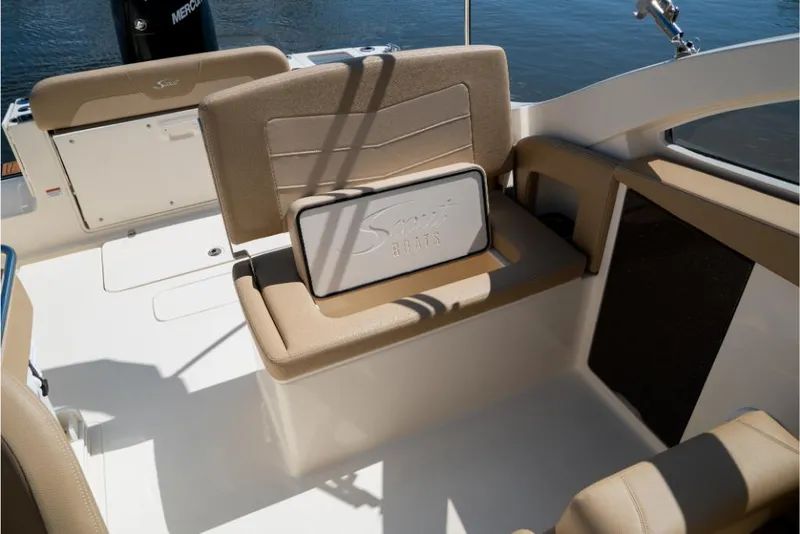 Slide: The Image of 2023 Scout 240 Dorado boat interior with beige seating and storage compartment. - 39