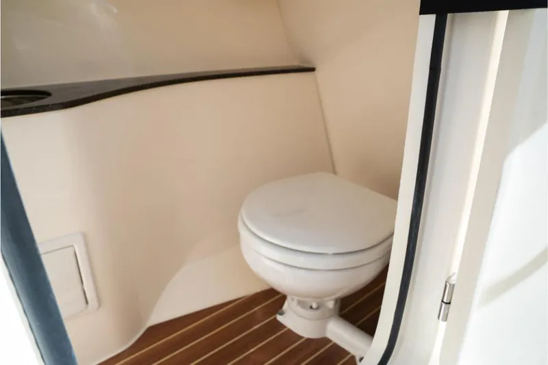 Slide: The Image of 2023 Scout 240 Dorado boat interior bathroom with toilet and wooden flooring. - 44