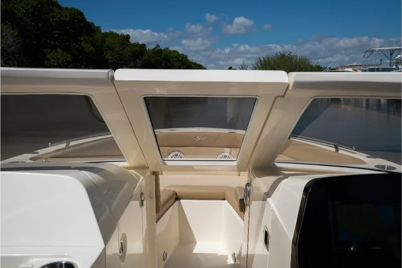 Slide: The Image of 2023 Scout 240 Dorado boat interior with open windshield on a sunny day. - 48