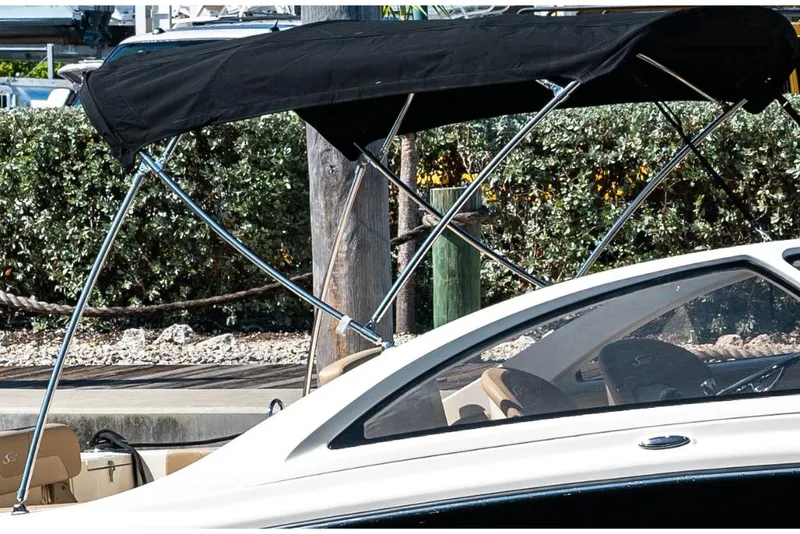 Slide: The Image of 2023 Scout 240 Dorado boat with black bimini top at dock. - 9