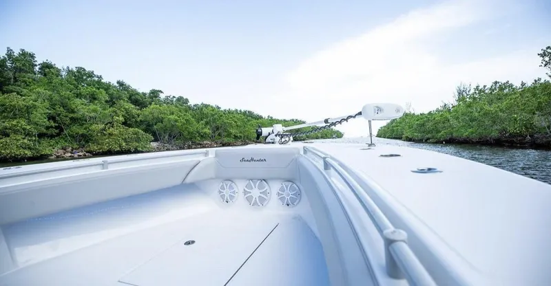 Slide: The Image of SeaHunter 28 Floridian 2021 on calm waters with lush green shoreline. - 3