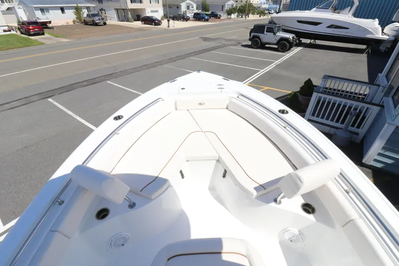 Slide: The Image of 2021 Sea Hunt Ultra 234 boat, white interior, parked in a lot near residential area. - 6