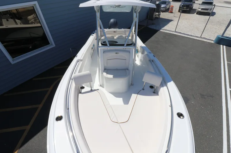 Slide: The Image of 2021 Sea Hunt Ultra 234 boat, white deck, parked outdoors near a building. - 7