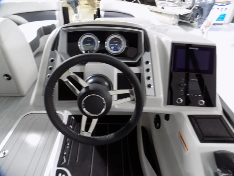 Slide: The Image of 2023 Barletta Corsa 23U boat dashboard with steering wheel and control panel. - 9
