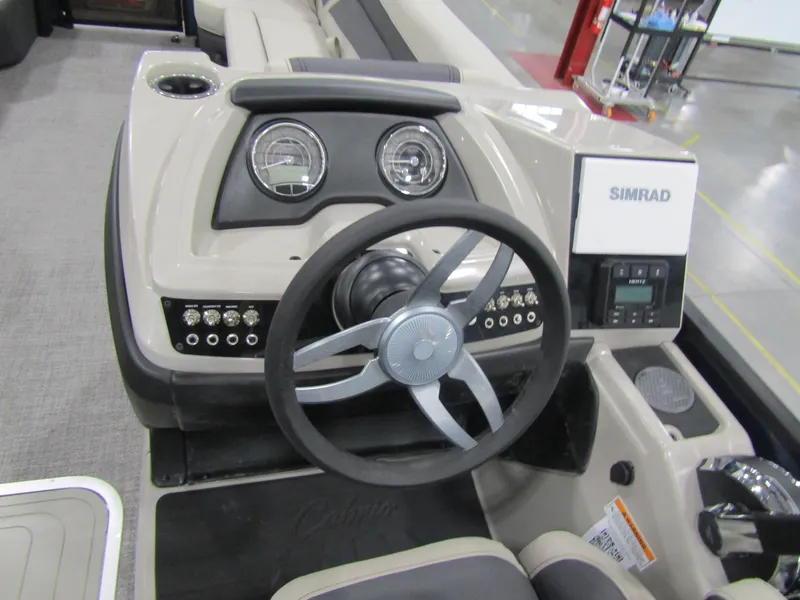 Slide: The Image of 2023 Barletta C24UC boat dashboard with steering wheel and Simrad display. - 3