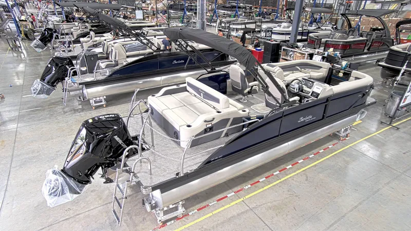 Slide: The Image of 2023 Barletta C24UC pontoon boat in a manufacturing facility, showcasing sleek design and modern features. - 6