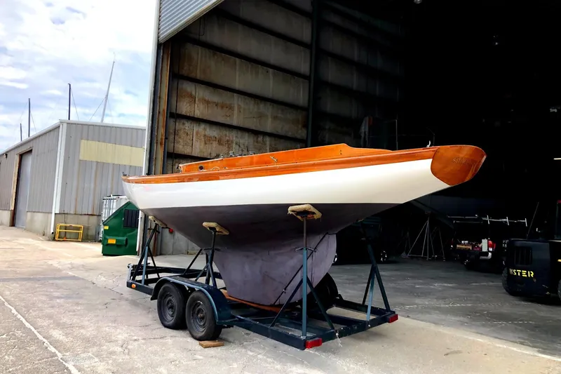 Slide: The Image of 1919 Herreshoff S Class sailboat on a trailer outside a large storage building. - 11