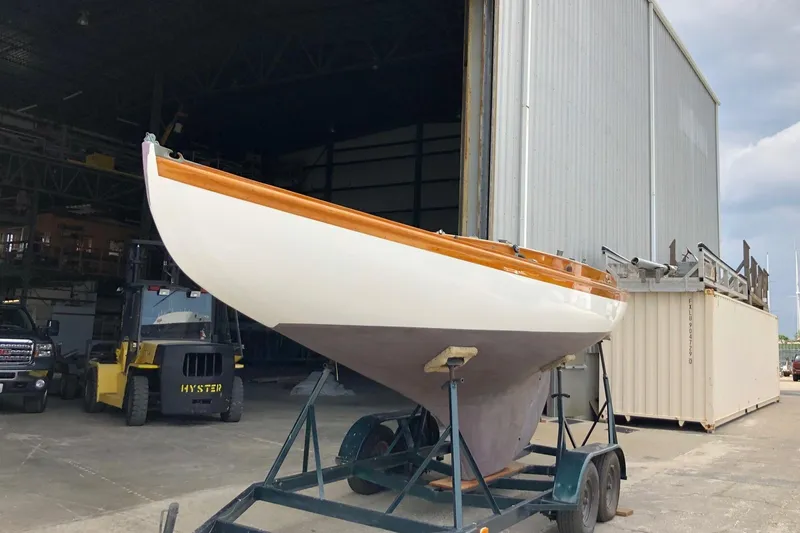 Slide: The Image of 1919 Herreshoff S Class sailboat on a trailer outside a storage facility. - 12