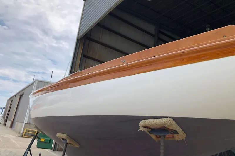 Slide: The Image of 1919 Herreshoff S Class sailboat in dry dock, showing hull and wooden trim. - 15
