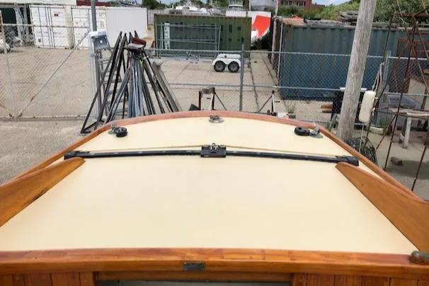 Slide: The Image of Herreshoff S Class 1919 boat deck with wooden trim in a shipyard. - 17