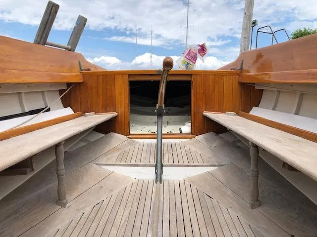 Slide: The Image of Interior of a 1919 Herreshoff S Class sailboat with wooden benches and tiller. - 5