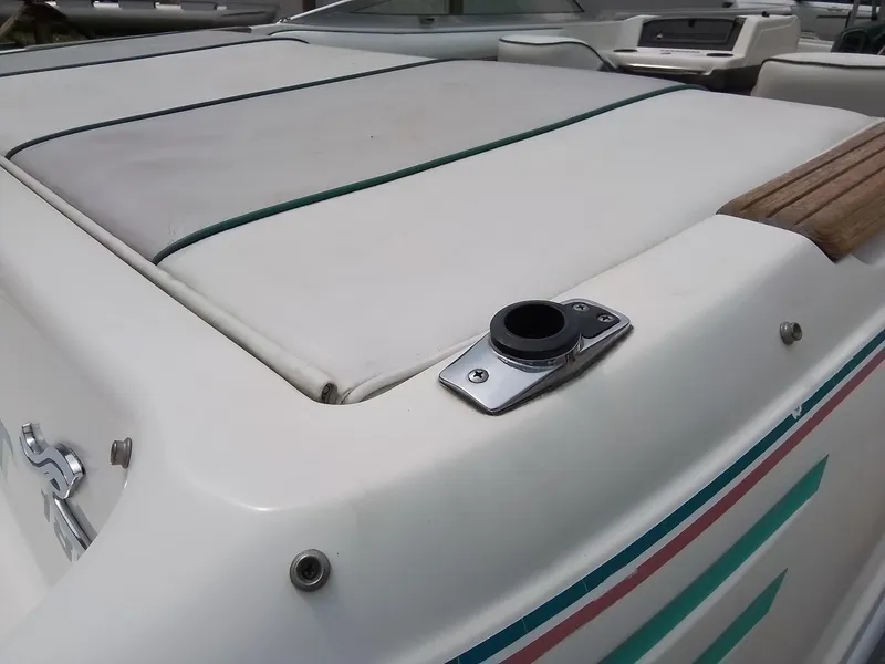 Slide: The Image of 1993 Sea Ray 180 BR boat with white cushioned seating and colorful stripes. - 11