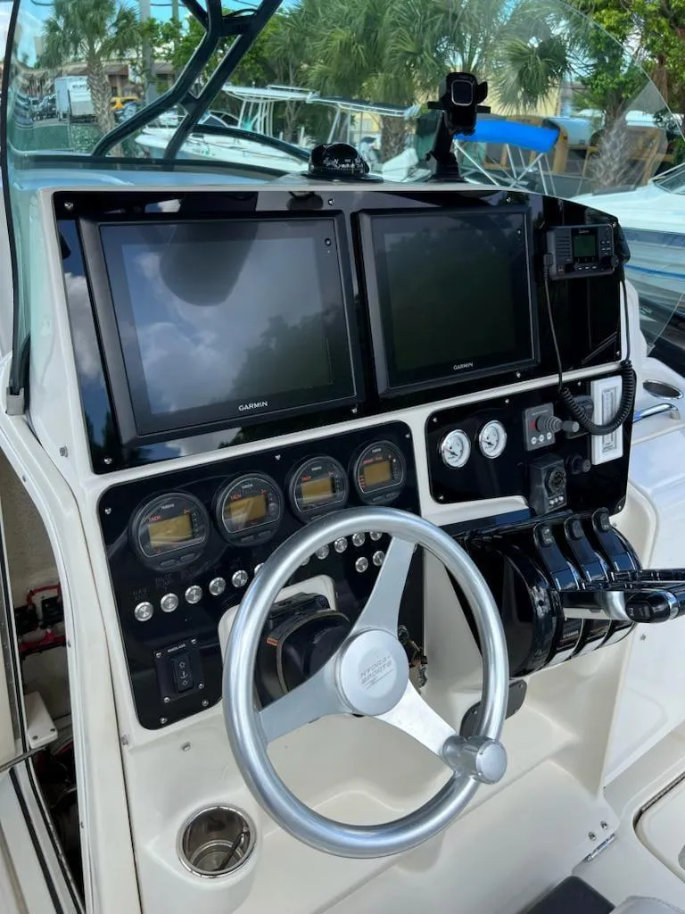 Slide: The Image of 2005 Hydra-Sports 3300 VX boat dashboard with dual Garmin displays and steering wheel. - 2