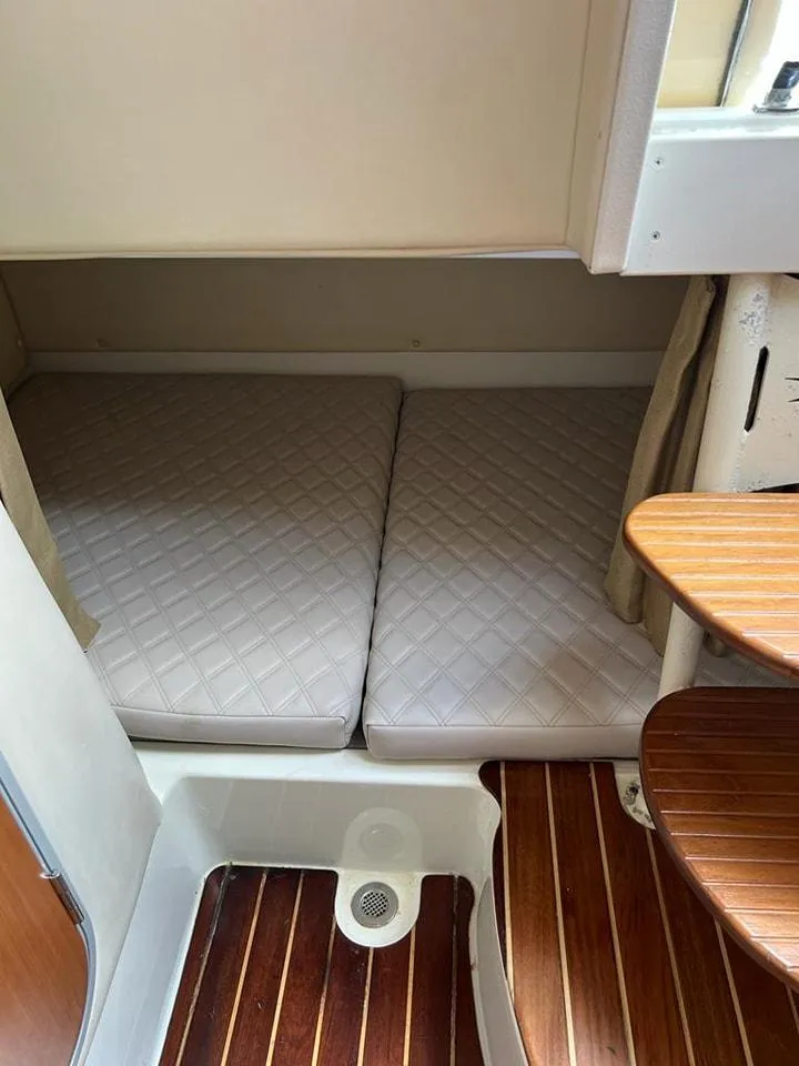Slide: The Image of 2005 Hydra-Sports 3300 VX cabin interior with twin mattresses and wooden flooring. - 25