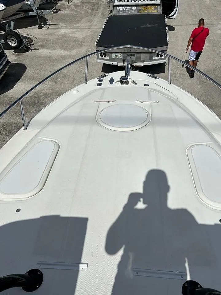 Slide: The Image of 2005 Hydra-Sports 3300 VX boat bow view with shadow and docked trailer. - 27