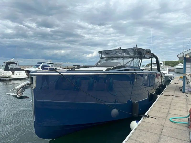Slide: The Image of 2024 Cranchi A46 yacht docked at marina under cloudy sky. - 1