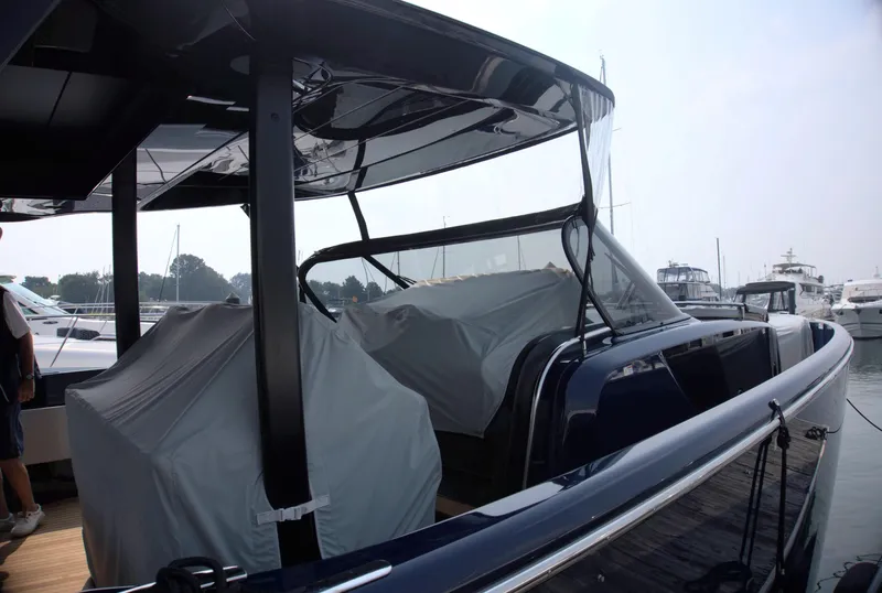 Slide: The Image of 2024 Cranchi A46 yacht docked at marina, covered seating area, sleek design. - 14