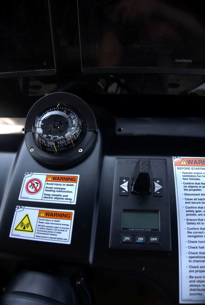 Slide: The Image of Control panel of 2024 Cranchi A46 yacht with compass and warning labels. - 16