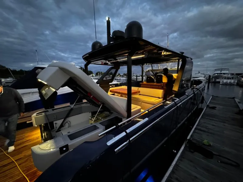 Slide: The Image of 2024 Cranchi A46 yacht docked at night, illuminated interior, sleek design. - 2