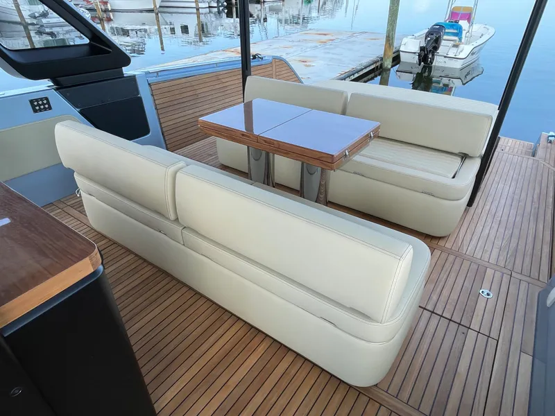 Slide: The Image of 2023 Cranchi A46 yacht interior with beige seating and wooden table. - 27