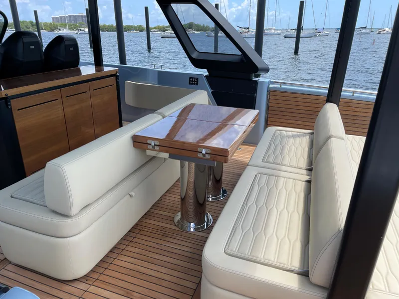 Slide: The Image of 2023 Cranchi A46 yacht interior with beige seating and wooden table. - 28