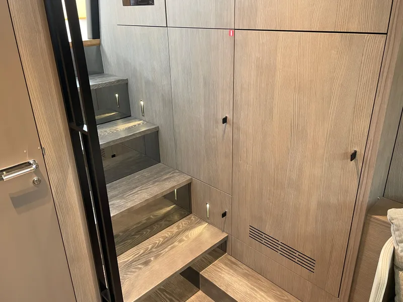 Slide: The Image of Interior of 2024 Cranchi A46 yacht with modern wooden stairs and cabinetry. - 32