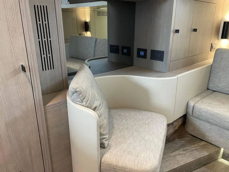 Slide: The Image of 2024 Cranchi A46 yacht interior with modern seating and wooden cabinetry. - 36