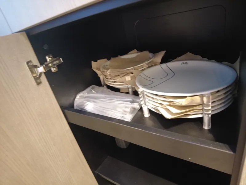 Slide: The Image of Plates and utensils stored in a cabinet on a 2023 Cranchi A46 yacht. - 40
