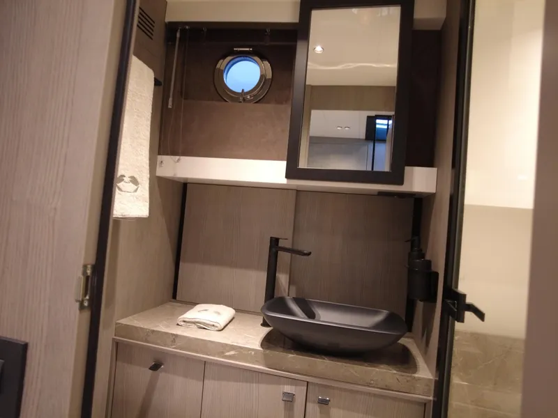 Slide: The Image of Luxurious bathroom interior of 2024 Cranchi A46 yacht with modern sink and porthole window. - 44