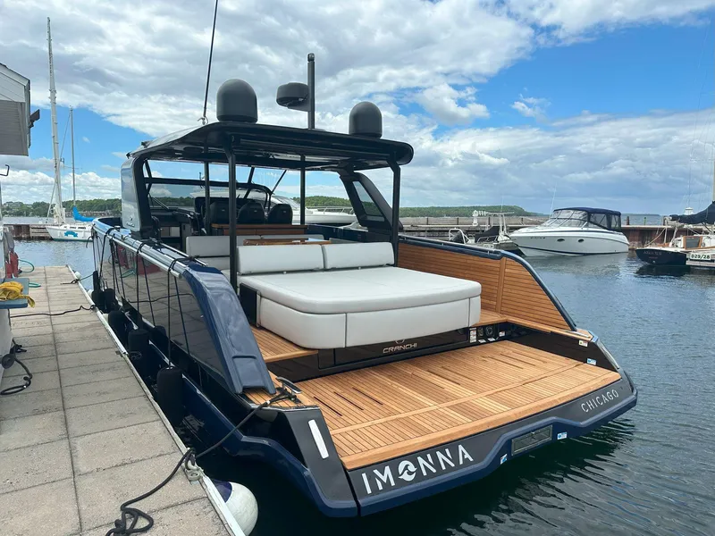 Slide: The Image of 2024 Cranchi A46 yacht docked, featuring sleek design and spacious deck in a marina setting. - 56