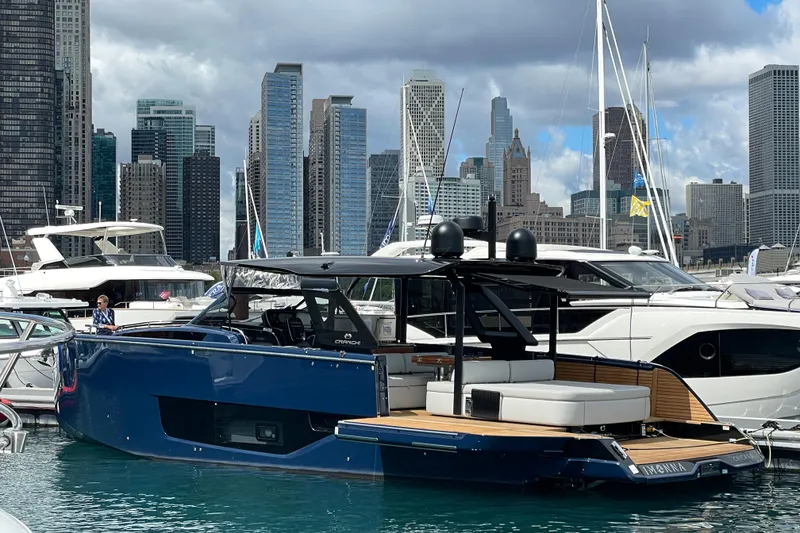 Slide: The Image of 2024 Cranchi A46 yacht docked in urban marina with city skyline backdrop. - 67