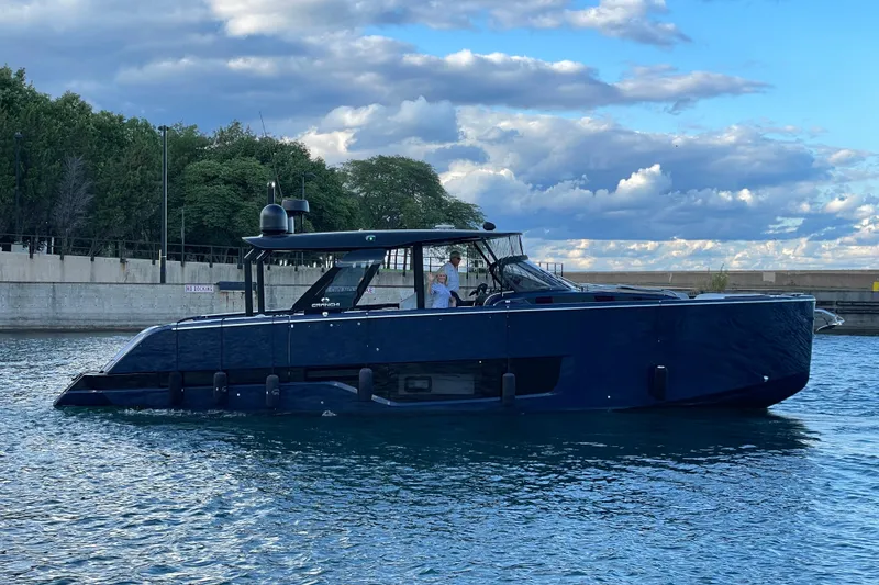 Slide: The Image of 2024 Cranchi A46 yacht cruising on a calm waterway under a partly cloudy sky. - 70