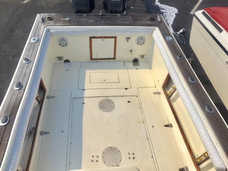 Slide: The Image of 1991 Mako 260 Walk Around boat deck with storage compartments and seating. - 11