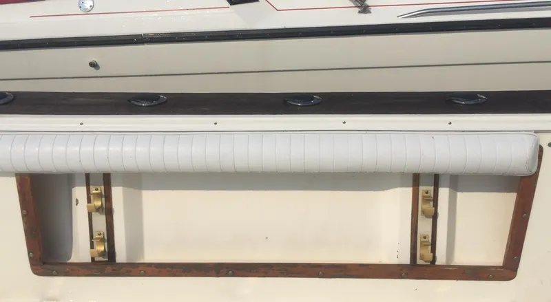 Slide: The Image of 1991 Mako 260 Walk Around boat interior detail with rod holders and cushioned rail. - 12