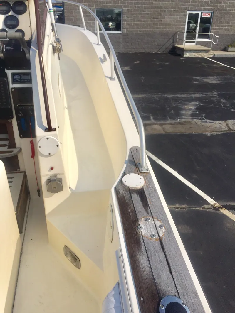 Slide: The Image of 1991 Mako 260 Walk Around boat deck with railing and control panel. - 15