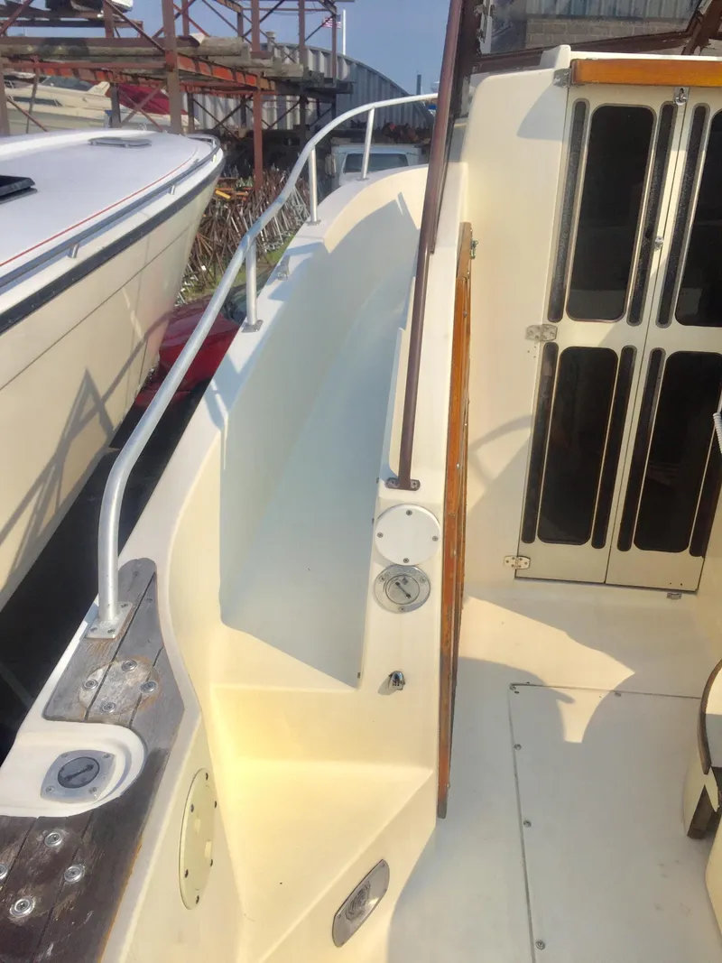 Slide: The Image of 1991 Mako 260 Walk Around boat deck with railing and cabin entrance. - 16