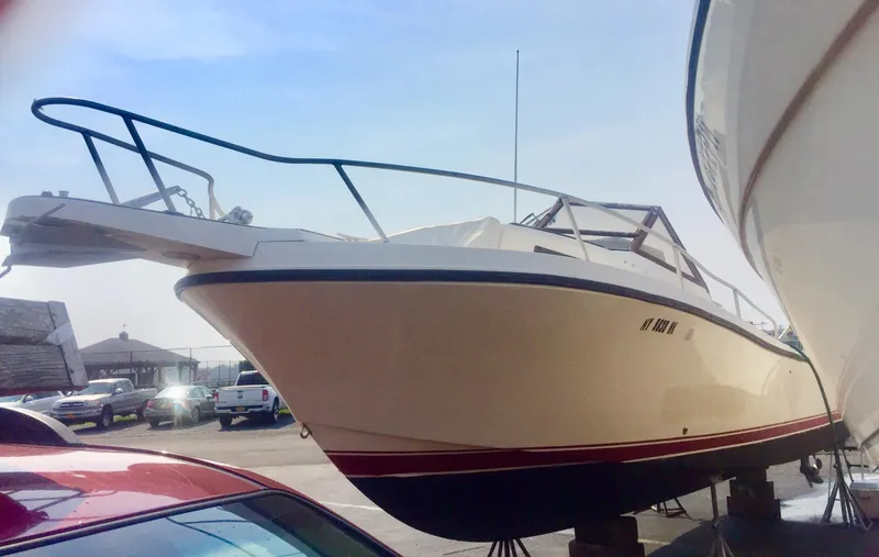 Slide: The Image of 1991 Mako 260 Walk Around boat on stands in a marina. - 2