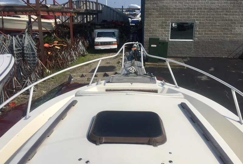 Slide: The Image of 1991 Mako 260 Walk Around boat docked near a storage facility. - 6