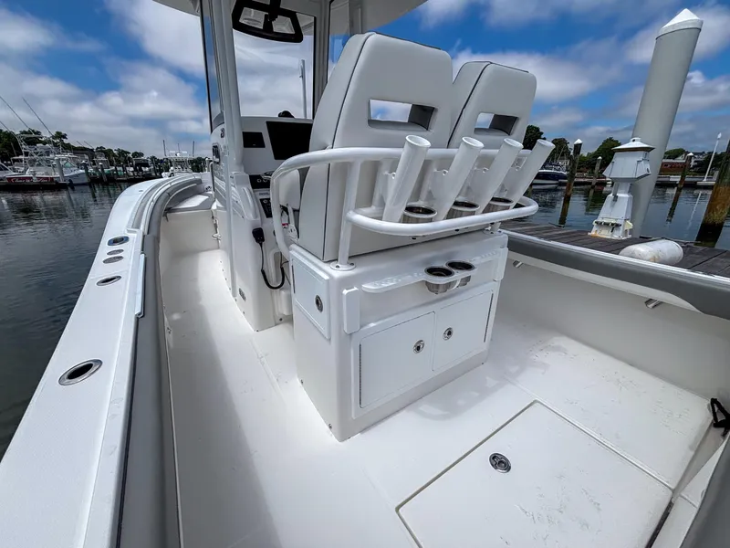 Slide: The Image of 2025 Regulator 23 boat interior with seating and rod holders, docked at a marina. - 13